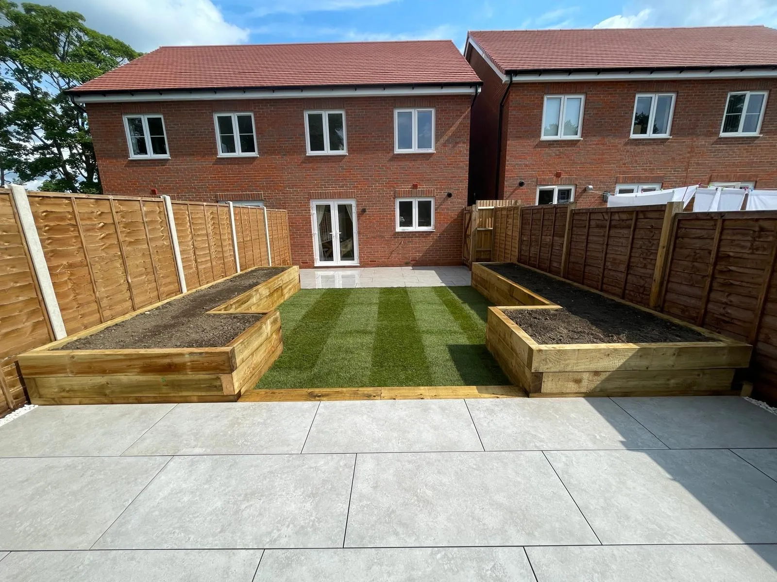 A backyard with a lawn and raised beds.