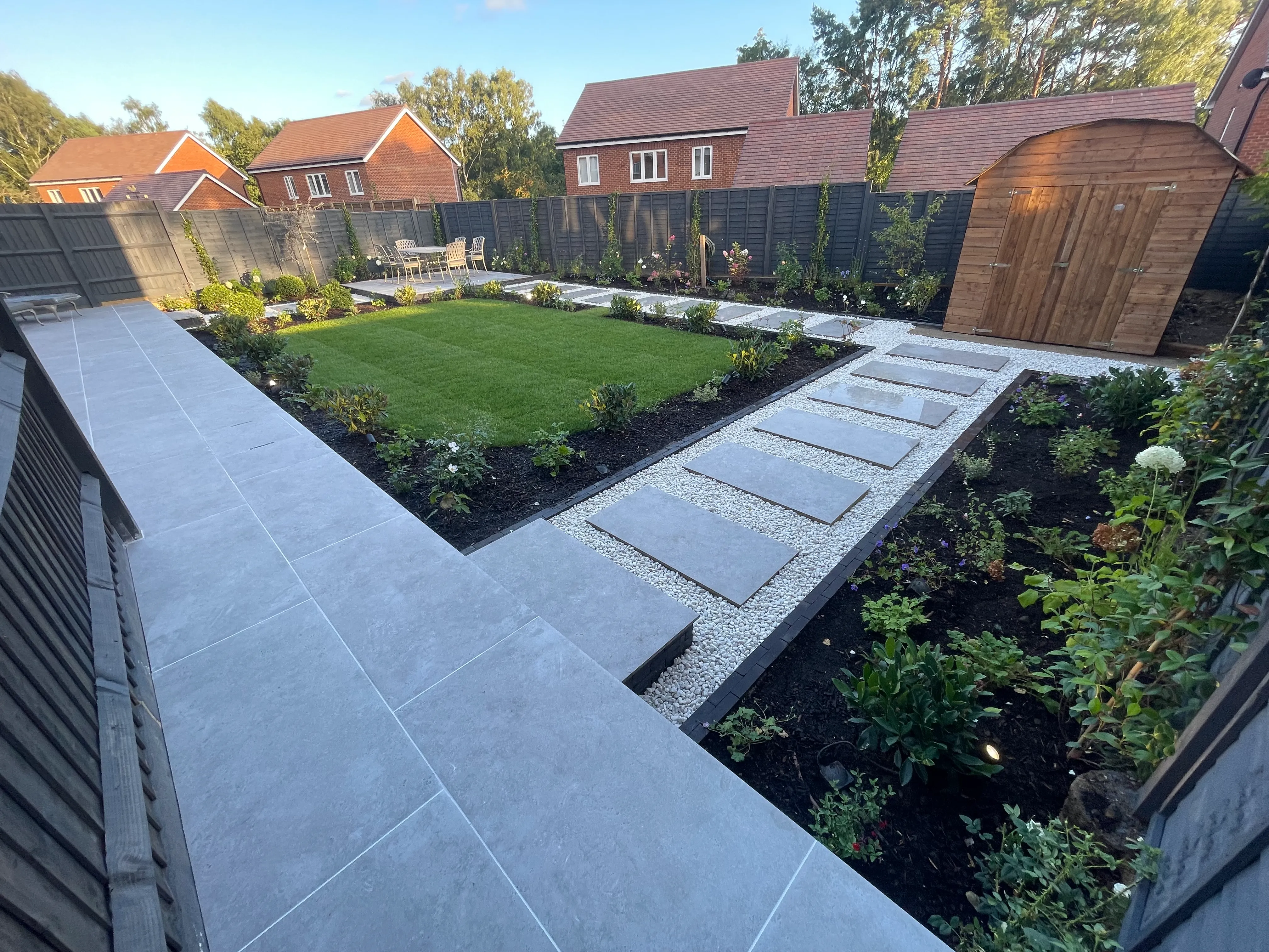 A backyard with a lawn and a stone path.